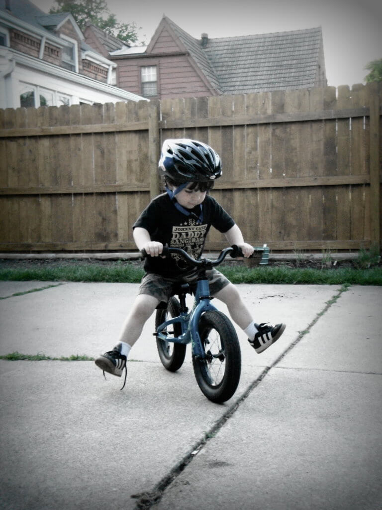 Young boy wearing a helmet while riding his bike.